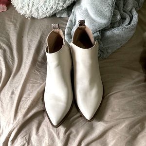 Cream color pointed toe boots with snakeskin strips on the back